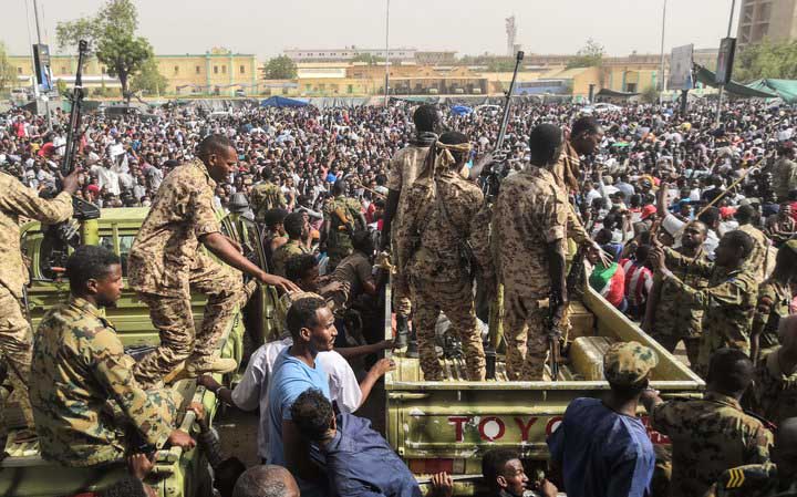 Sudanese soldiers stand guard on armoured vehicles as demonstrators protest in the capital, Khartoum.