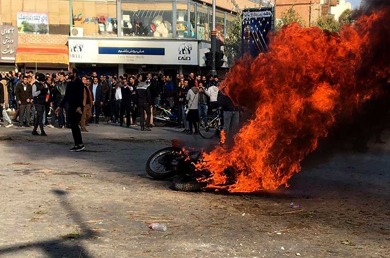 Protesters burn a motorcycle during a demonstration
