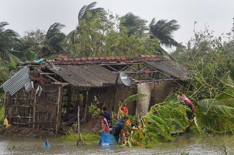 People collect belongings from the remnants of their house in the aftermath of Cyclone Bulbul